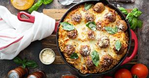 Mit Käse überbackene Fleischbällchen in Béchamelsauce
