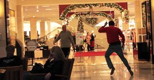 Mann in rotem Pullover und verrückten Tanzmoves verbreitet Weihnachtsstimmung in Einkaufszentrum