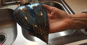 À l'aide d'une lampe torche, une femme trouve des cachettes à l'intérieur d'une décoration de Noël bleue qu'elle a acheté pour moins de  2 € dans un magasin discount