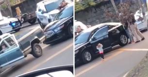 Un enfant s'approche les mains en l'air devant les policiers armés après l'arrestation de ses parents