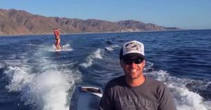 Hij filmt terwijl zij aan het wakeboarden is en realiseert zich dan dat ze niet alleen is in het water
