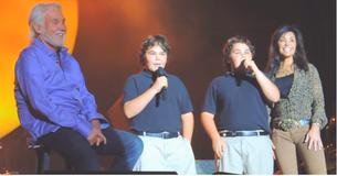 Kenny Rogers regarde avec fierté alors que ses deux fils jumeaux le rejoignent sur la scène pour chanter
