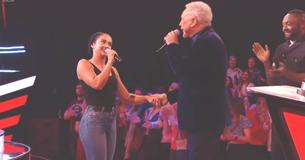 Jonge vrouw begint te zingen terwijl Tom Jones haar hand pakt voor dirty dancing nummer waardoor het publiek uit zijn dak gaat