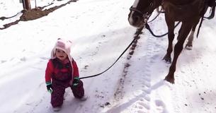 Une petite fille qui se promène à cheval dans la neige est coincée mais c'est l'action du cheval qui fait fondre le cœur de tout le monde