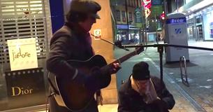 Obdachloser Mann bittet Straßenmusiker mitsingen zu dürfen. Als er anfängt zu singen, hören alle zu