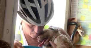 Vrouw die in hete woestijn fietst ontdekt een stervende puppy op een weg in niemandsland