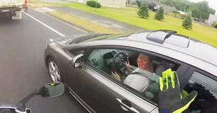 De onbeschofte bestuurder krijgt meteen karma nadat zij motor in tegemoetkomend verkeer probeert te duwen