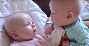 Vader ziet een tweelingbaby's een volwassen gesprek met elkaar voeren