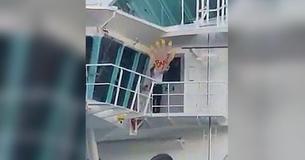 Membro dell'equipaggio di una nave da crociera saluta con mano gigante i passeggeri ritardatari che non sono riusciti a imbarcarsi
