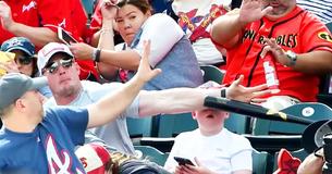 Vater beschützt seinen Sohn, als ein Baseball Schläger auf die Tribüne fliegt