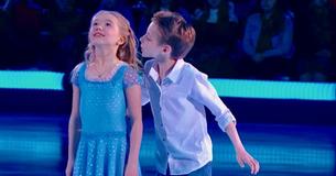 Un jeune garçon vole un baiser au début d'une performance de patinage sur glace