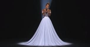 Jennifer Lopez porte une robe et des images lumineuses sont projetées sur elle lors de sa prestation à American Idol