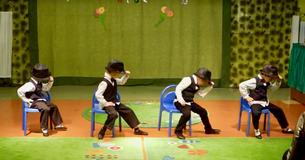 Quatre enfants d'âge préscolaire en costume impressionnent la foule par leurs mouvements