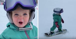 Une fillette d'un an ne s'arrête plus de sourire alors qu'elle se défoule sur son minuscule snowboard