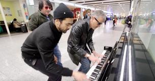 Drie mannen trekken publiek terwijl ze piano spelen op Heathrow Airport