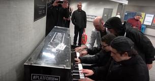 Quattro musicisti si riuniscono intorno a un pianoforte per suonare il boogie-woogie in una stazione della metropolitana