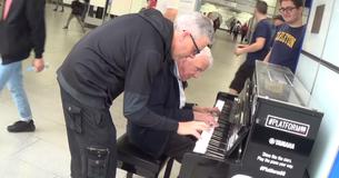Un anziano si siede a suonare il pianoforte e viene accompagnato da un pianista professionista: tutti si fermano ad ammirare il duetto