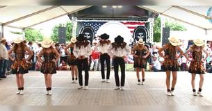 Groep tapdansers in cowboykleding doet een unieke versie van "Country Roads"