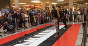 Frau und Mann spielen am Klavier und die Menge ist gefesselt