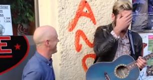 Un musicien de rue joue sur sa guitare alors qu'un chanteur connu s'approche de lui pour offrir un duo incroyable