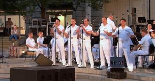 Gruppe souliger Navy-Matrosen führt Lieder aus den 60er Jahren vor und die Menge tobt