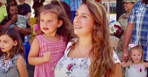 Une femme d'un militaire et sa fille de 3 ans crient de joie le retour à la maison de leur bien-aimé, dans une vidéo