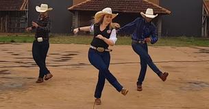 Un groupe de danseurs de ligne danse passionnément sur les rythmes de la chanson " Redneck Woman "