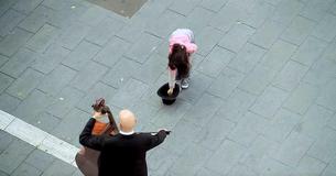 Une petite fille fait tomber des pièces de monnaie dans un chapeau et une flash mob incroyable commence