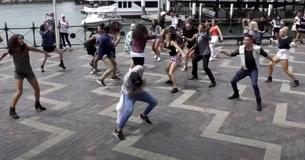 Breakdancers dansen op  "Uptown Funk" maar dan begint er een flashmob in de menigte op de promenade