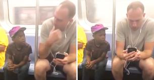 Man ziet kleine jongen naar zijn telefoon staren en is zich er helemaal niet van bewust dat medepassagier hem filmt