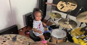 Getalenteerde 21 maanden oude baby speelt betoverend goed drums 