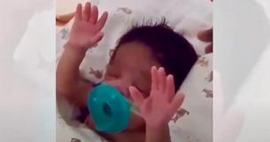 Moeder zingt Gospel-lied voor pasgeborene en baby kan het niet laten ter verering haar armen op te steken 