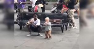 Un adorable bambin rejoint un groupe d'artistes de rue et participe au spectacle