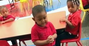 Un petit garçon de trois ans se tient debout devant ses camarades de classe pour prier