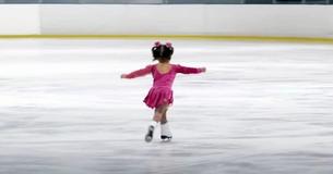 Une petite patineuse glisse sur la glace et fait signe à sa mère avant de voler la vedette avec une adorable routine