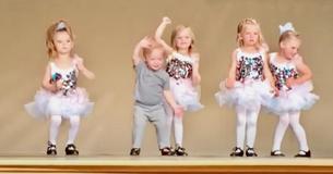 Kleiner Junge platz auf liebenswerte Weise in die Ballettaufführung seiner Cousine und bringt das Publikum zum Lachen