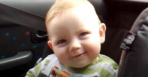 Baby kämpft mit seinem bezaubernden Lächeln gegen den Schlaf an