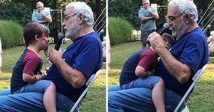 Großvater bringt seinem Enkel mit Downsyndrom auf der Geburtstagsfeier ein Ständchen