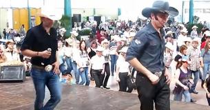 Denim-Clad Men Tempt Audience To Join Them In Line Dance